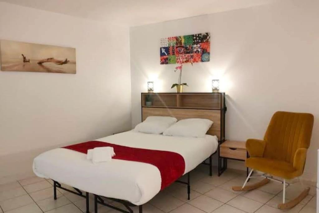 Habitación de hotel con cama y silla en Appartement au calme ORSAY PARIS, en Orsay