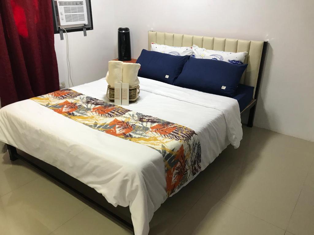 1 dormitorio con 1 cama grande con almohadas azules en Mikhai Guest House near Las Cazas de Acuzar, en Bagac