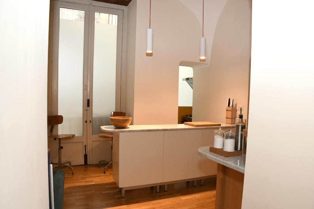 uma cozinha com armários brancos e um espelho em Casa Cammarota em Nápoles