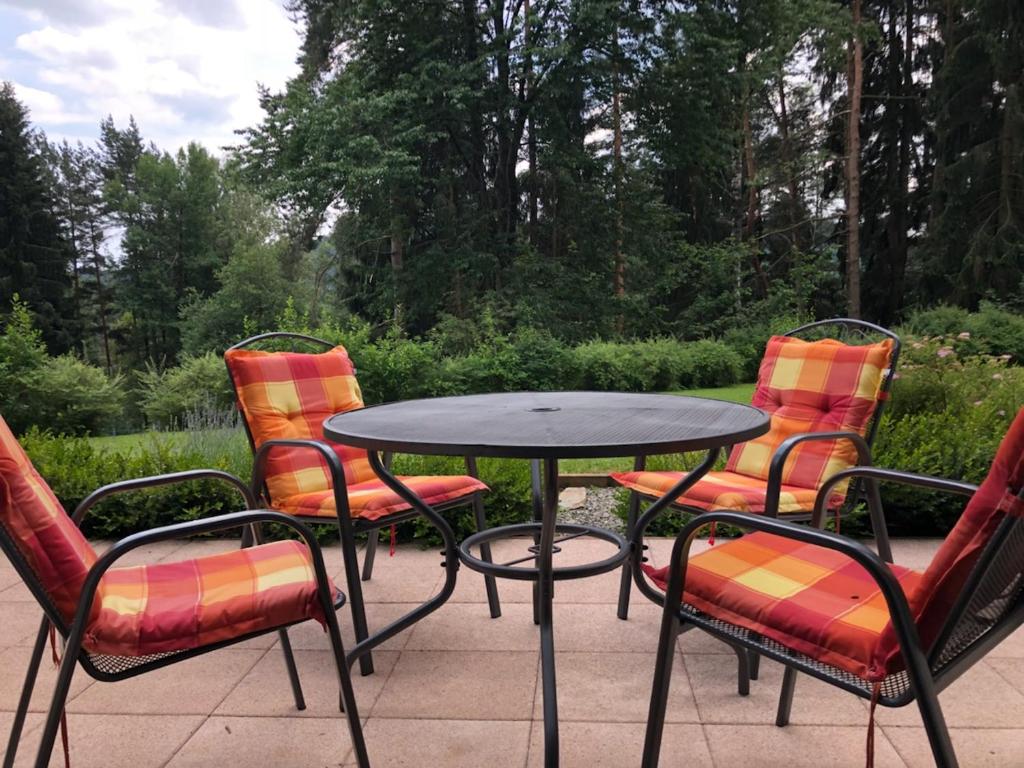 einen Tisch und vier Stühle um einen Tisch herum in der Unterkunft Harmonie Apartment in Lipno nad Vltavou