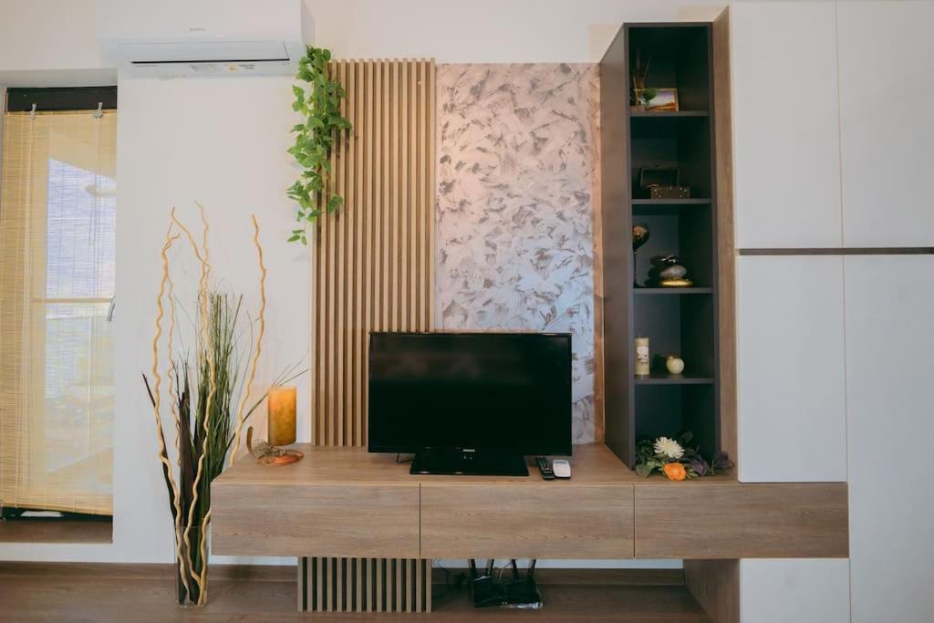 a television sitting on a wooden entertainment center in a living room at Plaza View in Bucharest