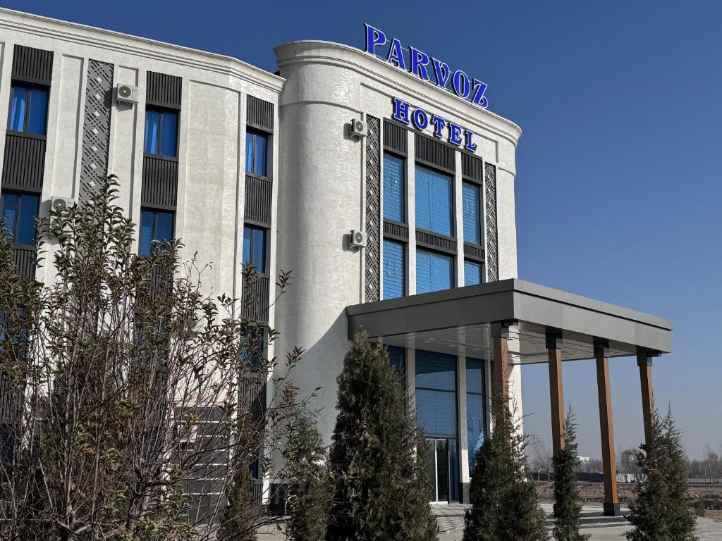 a building with a sign on the side of it at Parvoz Hotel in Urganch