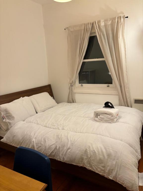 una camera da letto con un letto e un gatto seduto sopra di Room137 Stay in Stoke Newington a Londra