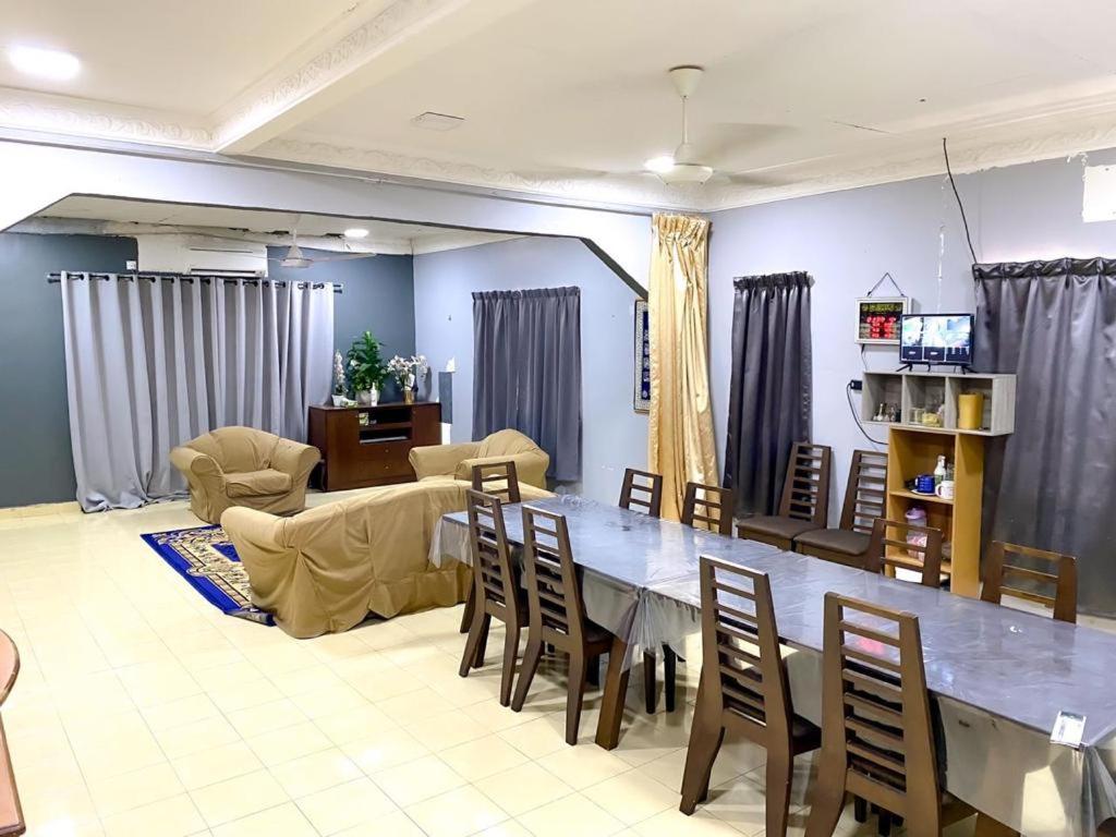 a living room with a large table and chairs at Family's Homestay in Kuala Terengganu