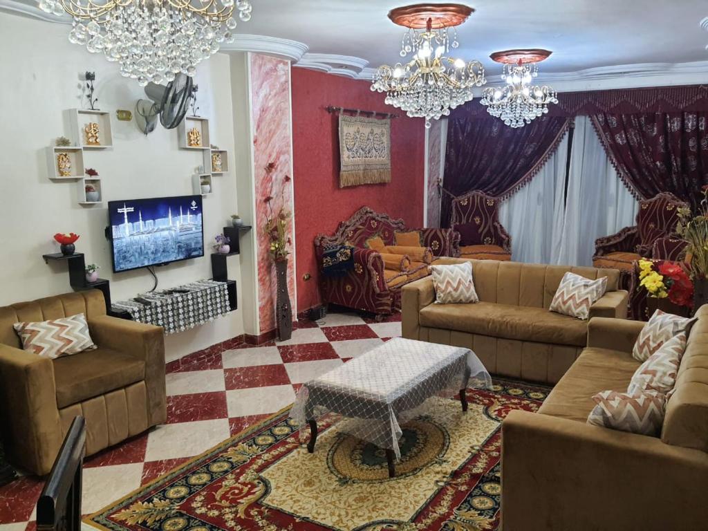 uma sala de estar com sofás e uma televisão em شقة مفروشة no Cairo