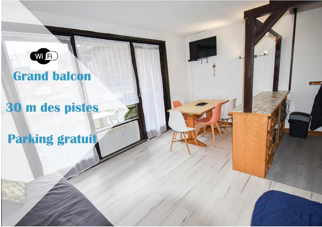 a room with a table and chairs and a large window at Relai S11 Grand et lumineux studio avec coin montagne 4-6 pers, WIFI, 30m des pistes, grand balcon, DRAPS NON COMPRIS in Saint-Jean-d'Aulps