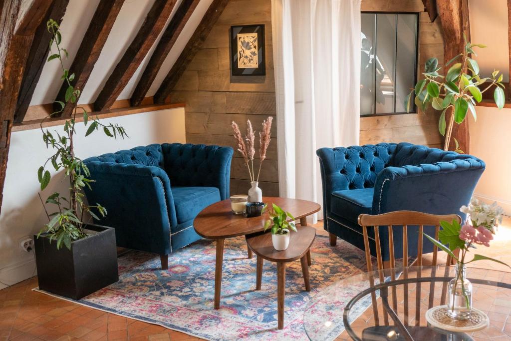 a living room with two blue couches and a table at Suite Toussaint - Calme & Authentique in Angers
