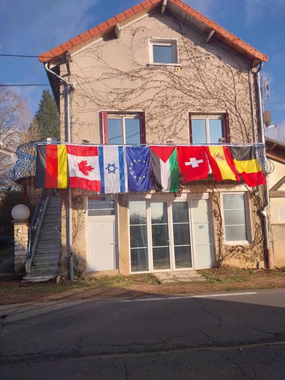 une maison arborant des drapeaux colorés à l'avant dans l'établissement L'amarre aux anges, à Cormatin