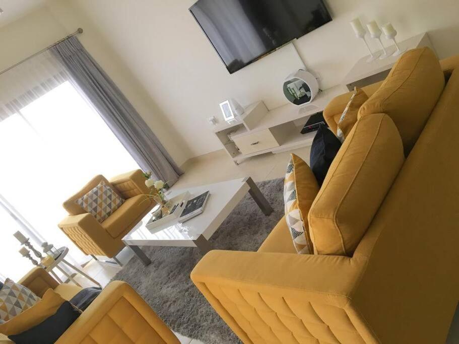 ein Wohnzimmer mit einem Sofa, Stühlen und einem Tisch in der Unterkunft City Gem - Qurm in Muscat