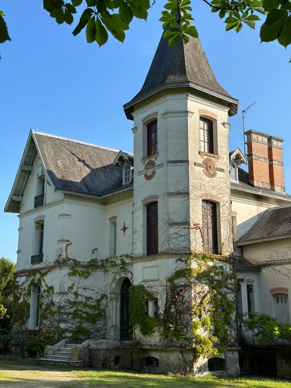 una vecchia casa con una torre sopra di Château de Moulède 