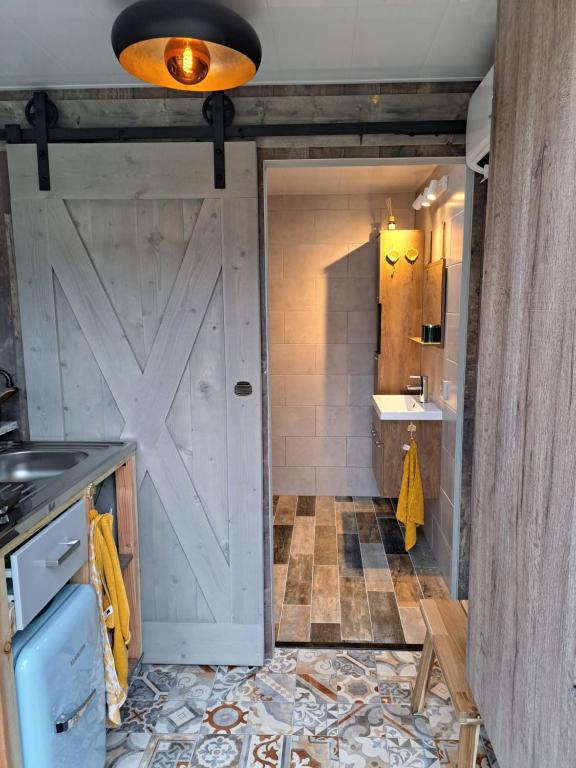 a bathroom with a barn door and a sink at bnbheerhugowaard in Heerhugowaard