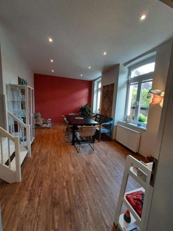 ein Wohnzimmer mit einem Esstisch und einer roten Wand in der Unterkunft Diana's Stube in Krefeld
