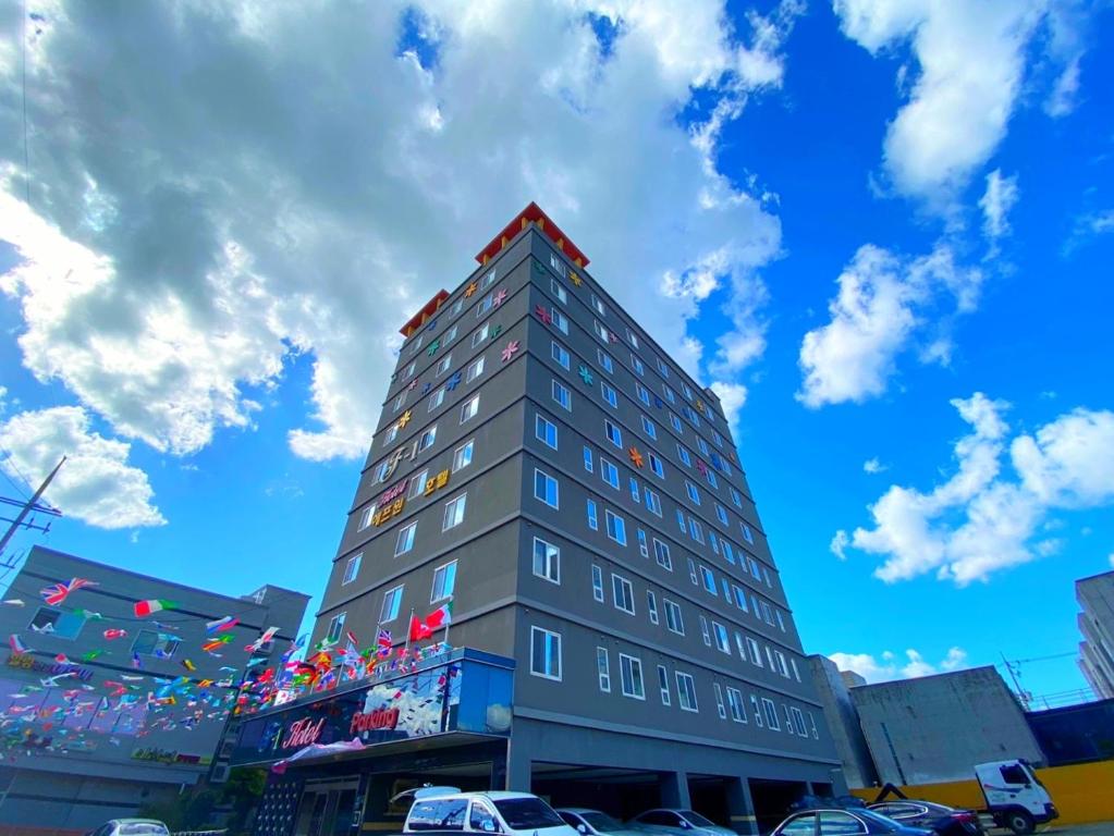 a tall gray building with a sky in the background at F1 Hotel in Mokpo