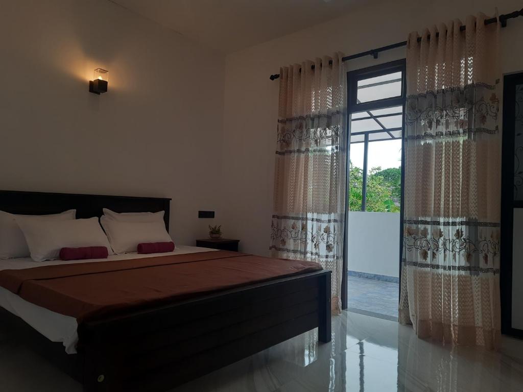 a bedroom with a bed and a large sliding glass door at Villa Sunset Tides in Weligama