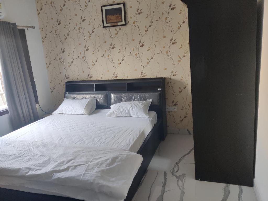 a bed with white sheets and pillows in a bedroom at Osho home in Lucknow