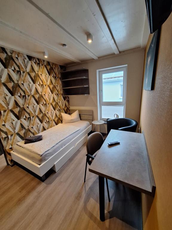 Un dormitorio con una cama y una mesa. en Pension Eichsfeld Zimmer 3 en Breitenworbis