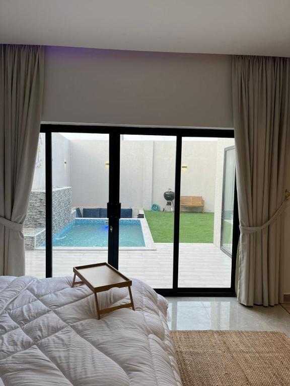 a bedroom with a bed and a view of a pool at شاليهات بالما in Al Hofuf
