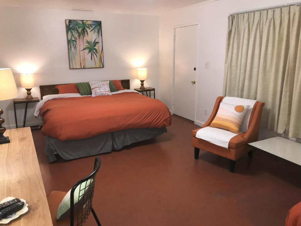 a bedroom with a bed and a chair and a table at Aloha Hotel Palm Springs in Palm Springs
