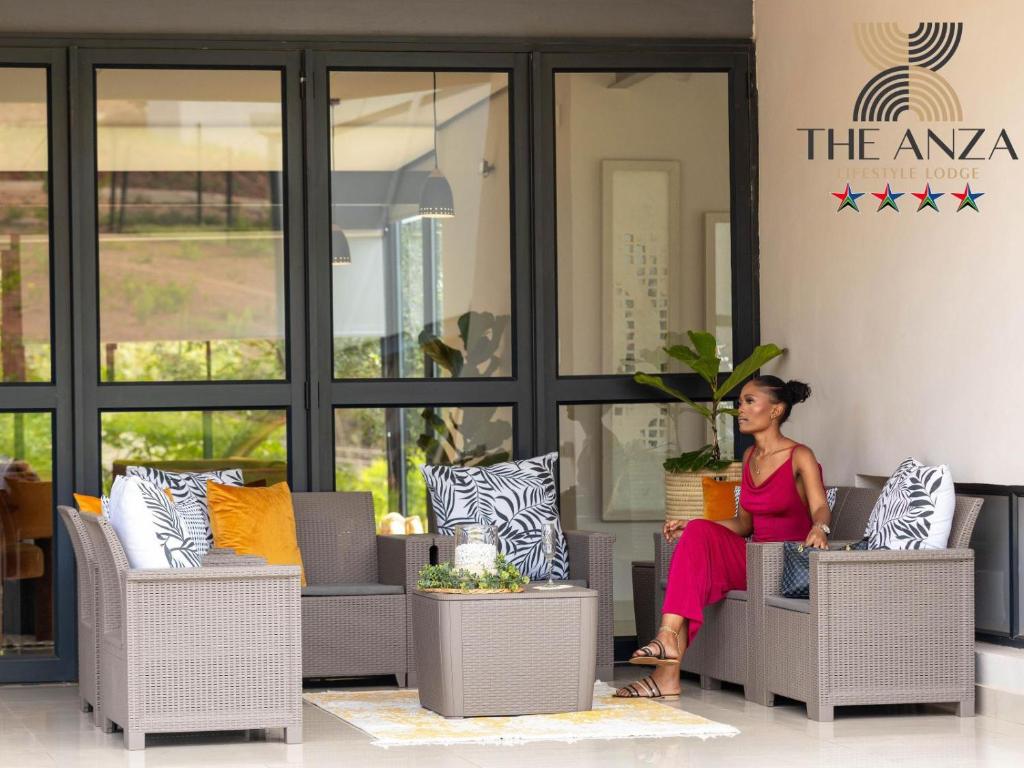 a woman sitting on a chair in a room at The Anza Lifestyle Lodge in Louis Trichardt