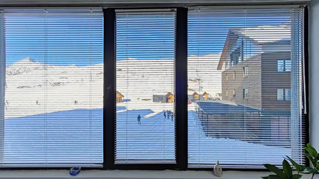 uma janela com vista para um pátio coberto de neve em GVC 210 New Gudauri Mountain View em Gudauri