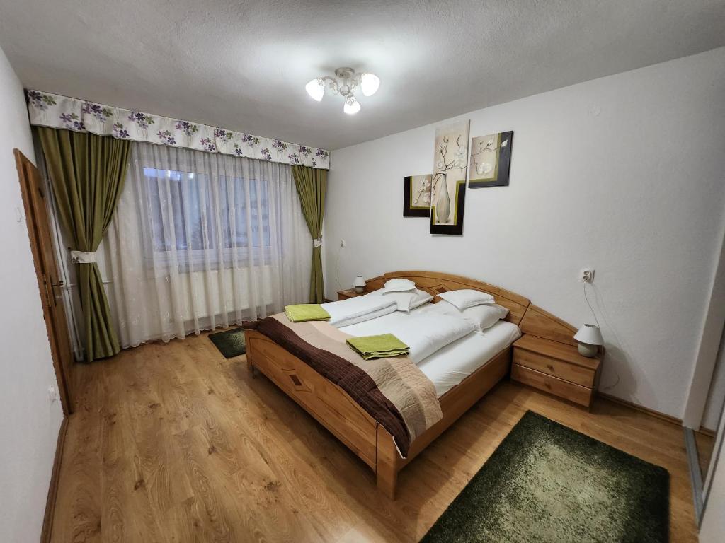 um quarto com uma cama e uma grande janela em Grand Central House em Odorheiu Secuiesc