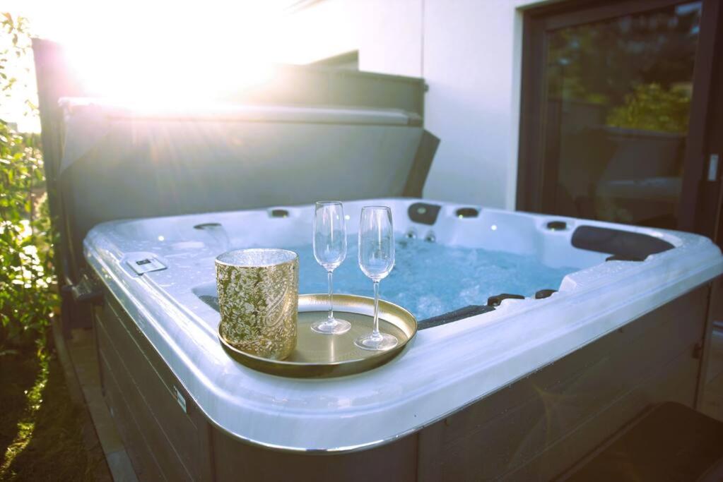 een hot tub met 2 glazen en een dienblad met wijnglazen bij Beautiful 4BR House with Jacuzzi in Sandweiler