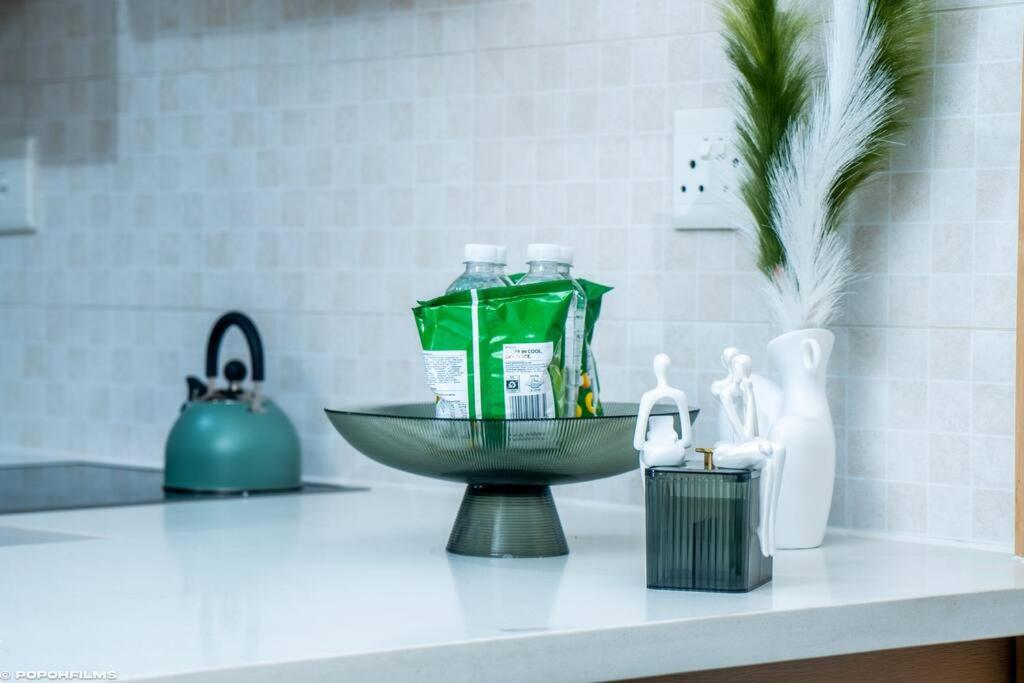 um balcão de casa de banho com um lavatório e uma tigela em Emerald Gem-Luxury Apartment em Sandton