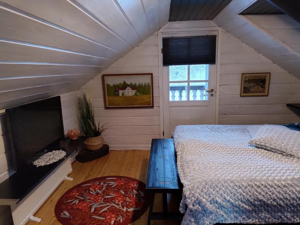 a attic bedroom with a bed and a window at Villa Bear's in Rovaniemi