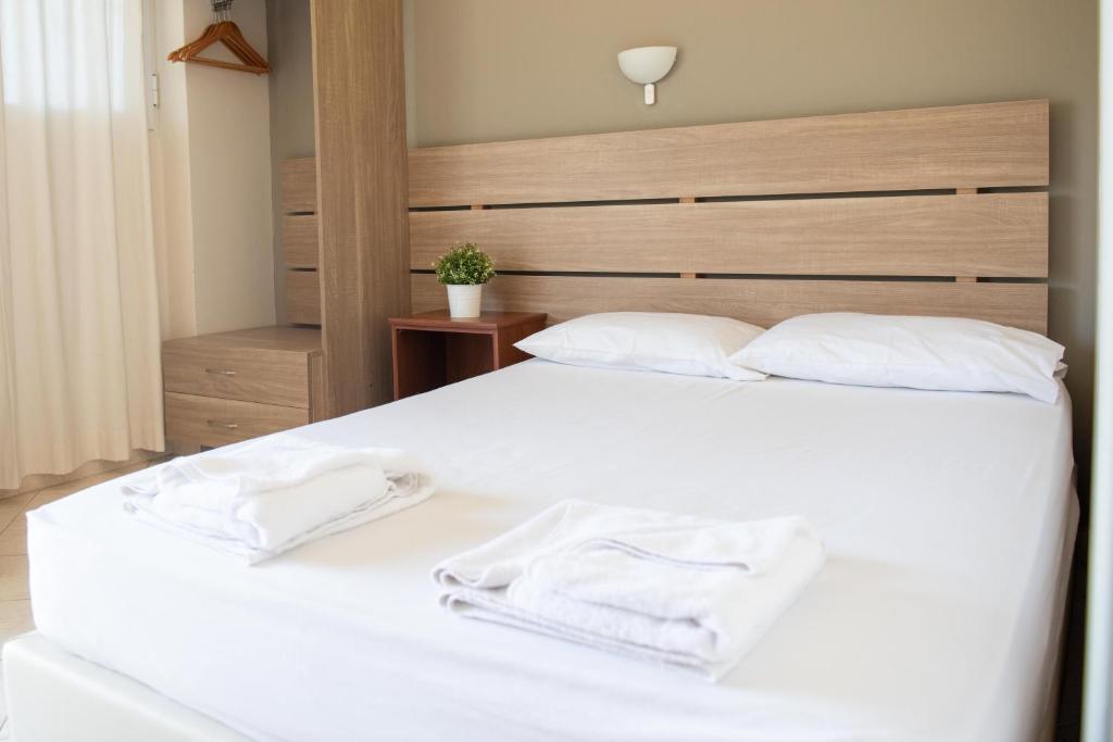 a bedroom with a white bed with two towels on it at Tota Marinou in Trikovilón