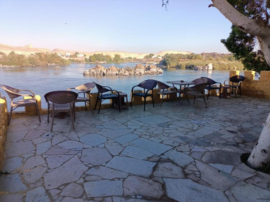 a group of tables and chairs next to a river at Go Inn Backpackers in Aswan