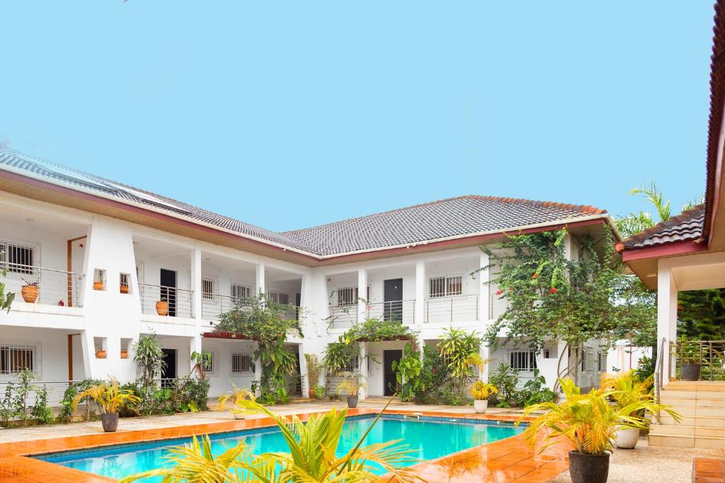 an image of the exterior of a hotel with a swimming pool at BRAGHA APARTMENTS in Sekondi-Takoradi