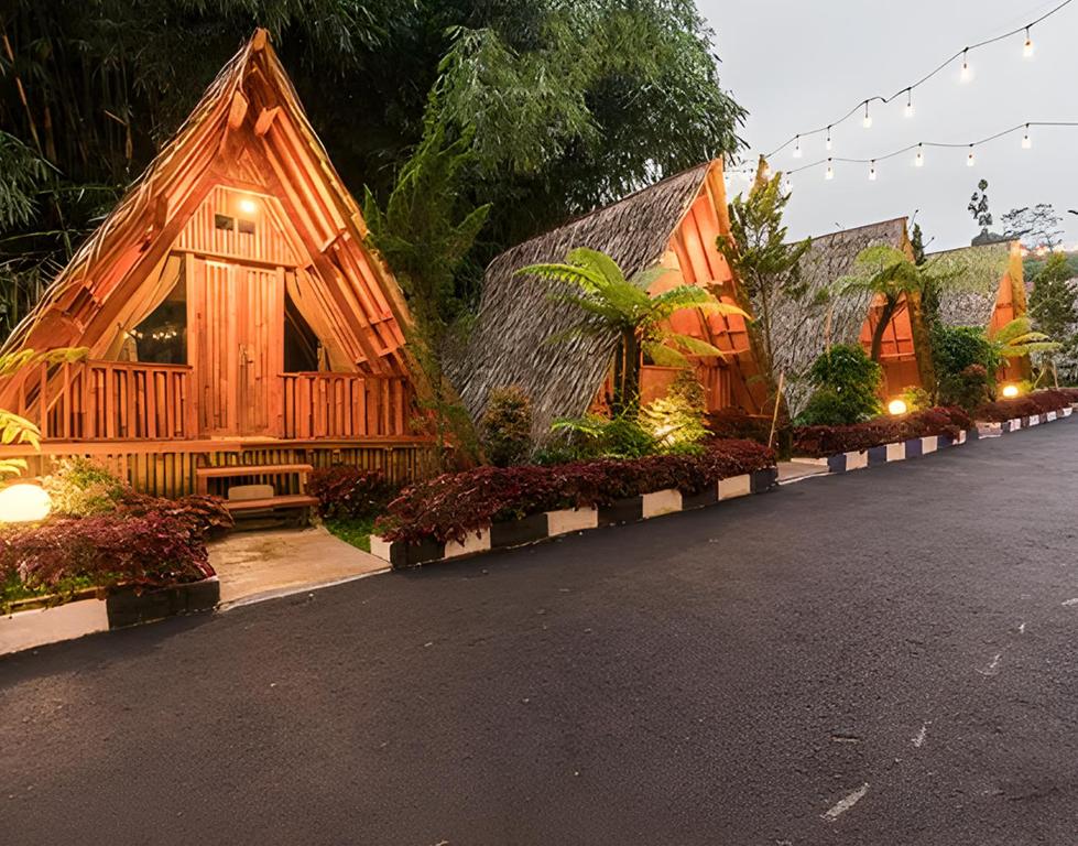 een houten huis met lichten aan de kant van een weg bij New DGYP Ciater Resort in Ciater
