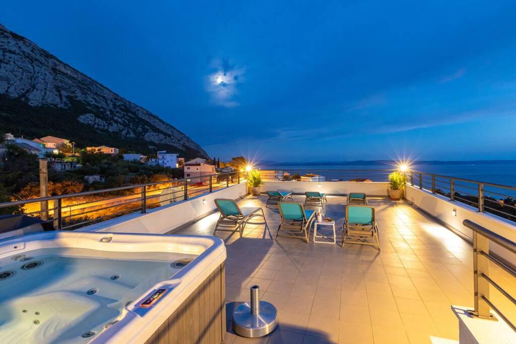 d'un bain à remous sur un balcon avec vue sur l'océan. dans l'établissement VillaPetra ; Veliko Brdo, à Makarska