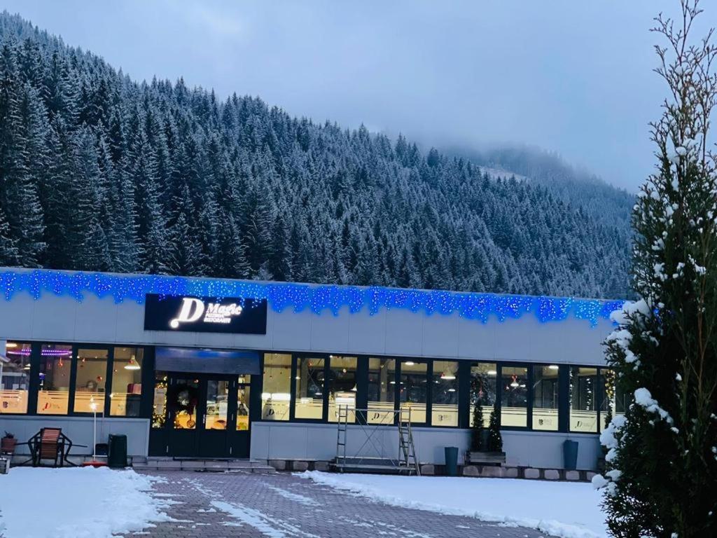 a building with a sign on it in the snow at D' Magic in Broşteni