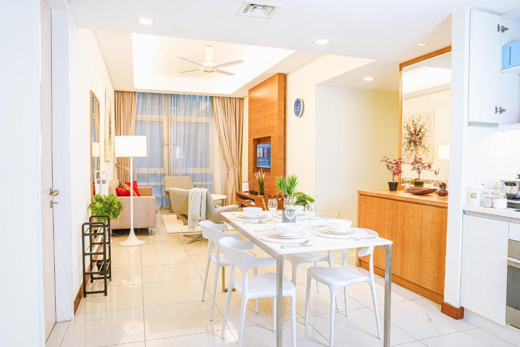 a kitchen and dining room with a white table and chairs at 9 PAX, 2BR Balcony, 3mins to KLCC - 3A03 in Kuala Lumpur