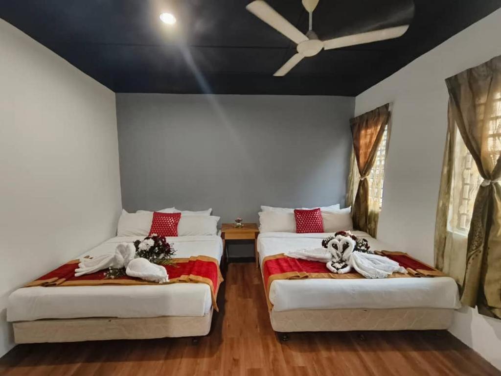 ein Schlafzimmer mit zwei Betten mit ausgestopften Tieren in der Unterkunft 1 Hati Homestay Sepang in Sepang