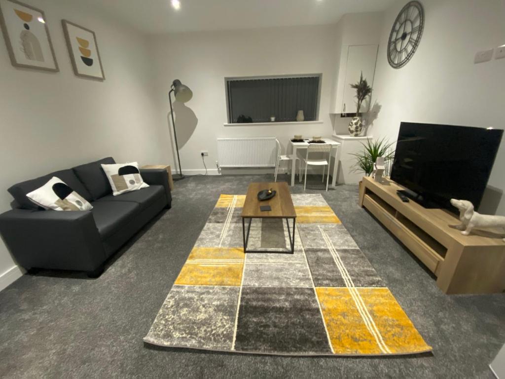a living room with a couch and a tv at 1 bedroom apartments in Bolton town centre in Bolton