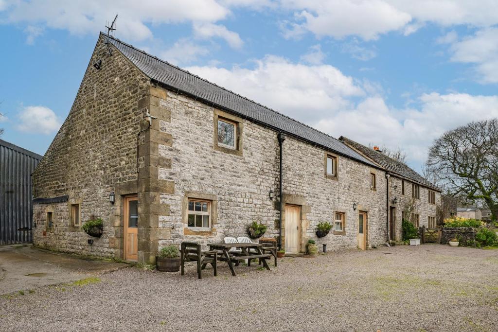a stone building with a picnic table in front of it at Host & Stay - The Barn - Upper Farm in Tideswell