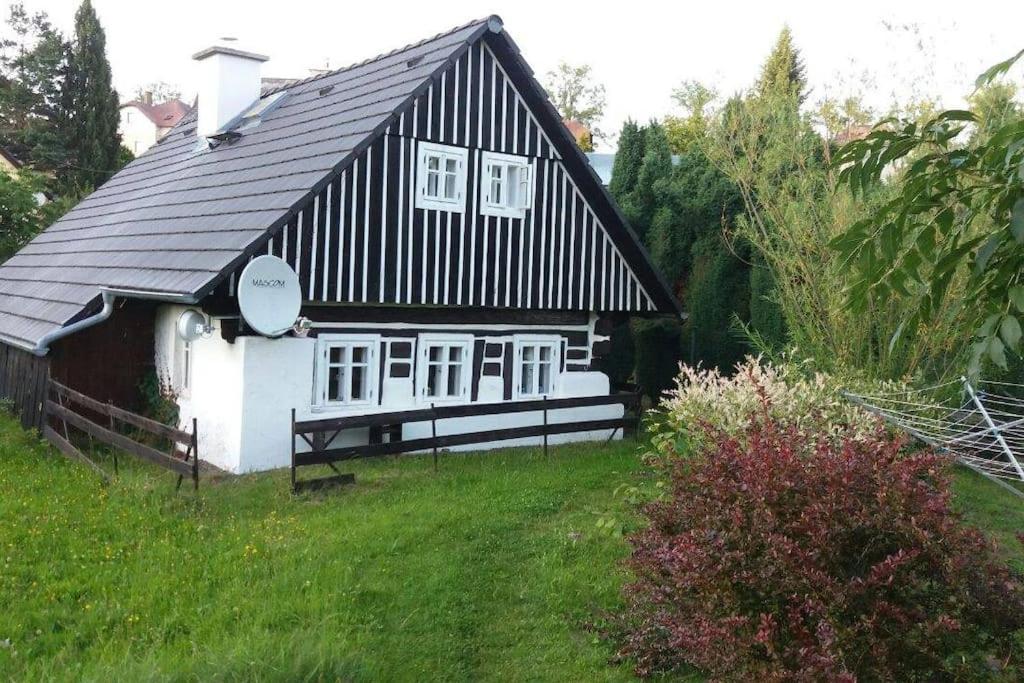 una casa en blanco y negro en un campo en Roubená chalupa v Jilemnici v klidné lokalitě, en Semily
