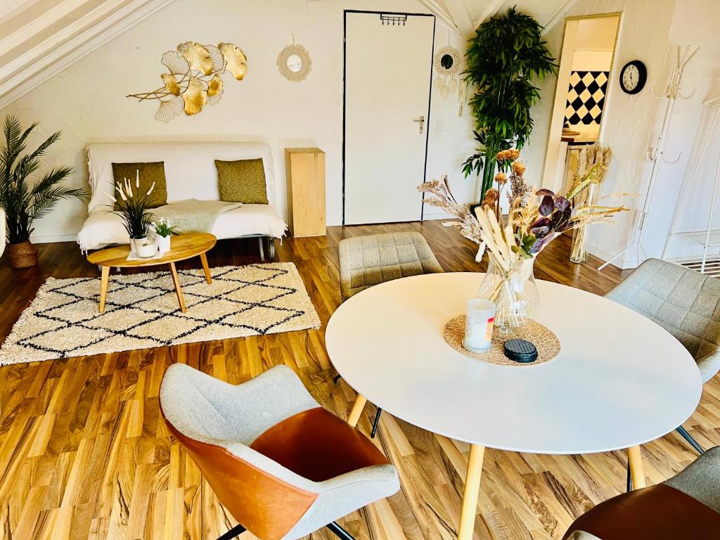 ein Wohnzimmer mit einem Tisch und Stühlen in der Unterkunft Große Dachgeschosswohnung mit Küche und Badezimmer an der Uniklinik Homburg in Homburg
