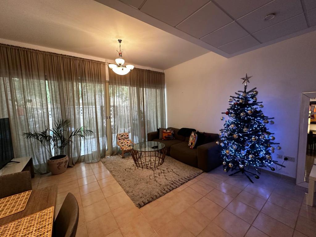 a living room with a christmas tree and a couch at Peaceful home near beach & car in Dubai