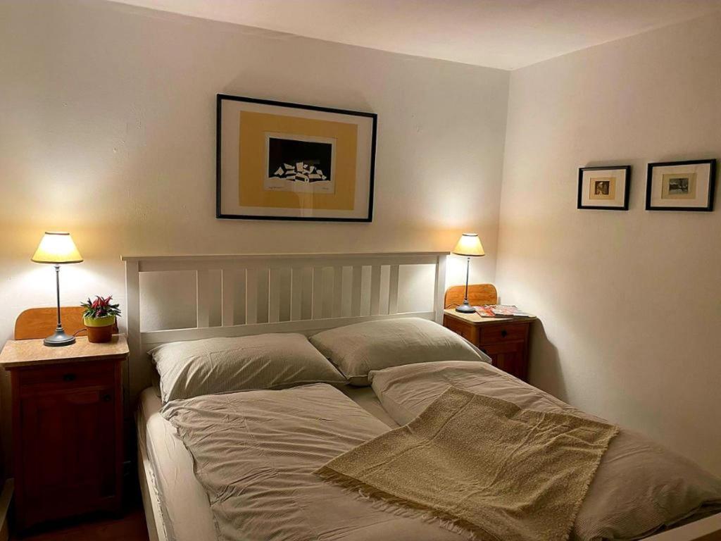 um quarto com uma cama com duas mesas de cabeceira e dois candeeiros em Ferienhaus Plessberg 
