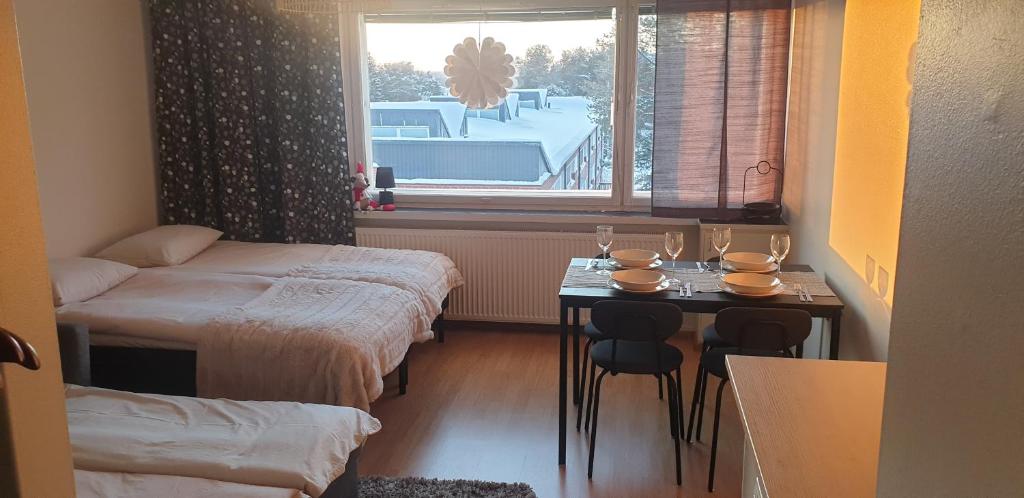 罗瓦涅米Arctic Condo at City Centre的有两张床、一张桌子和一扇窗户的房间
