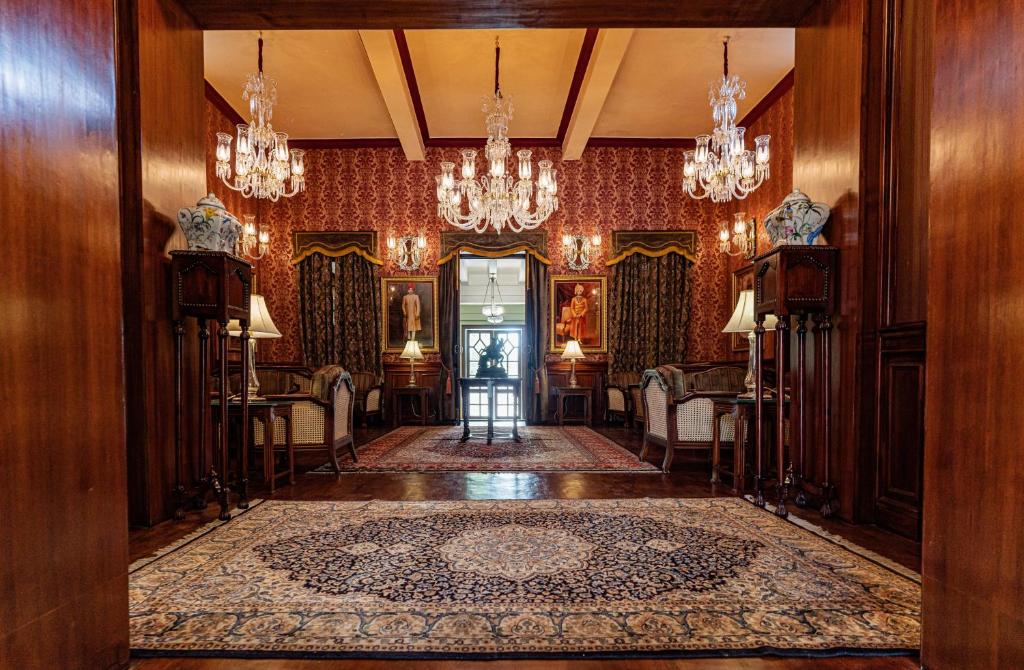 um corredor com um quarto com lustres em The Ajit Bhawan - A Palace Resort em Jodhpur