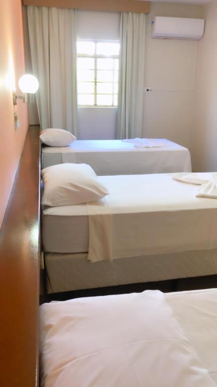 a group of four beds in a room at HOTEL VILLA QUATI CENTRO in Foz do Iguaçu