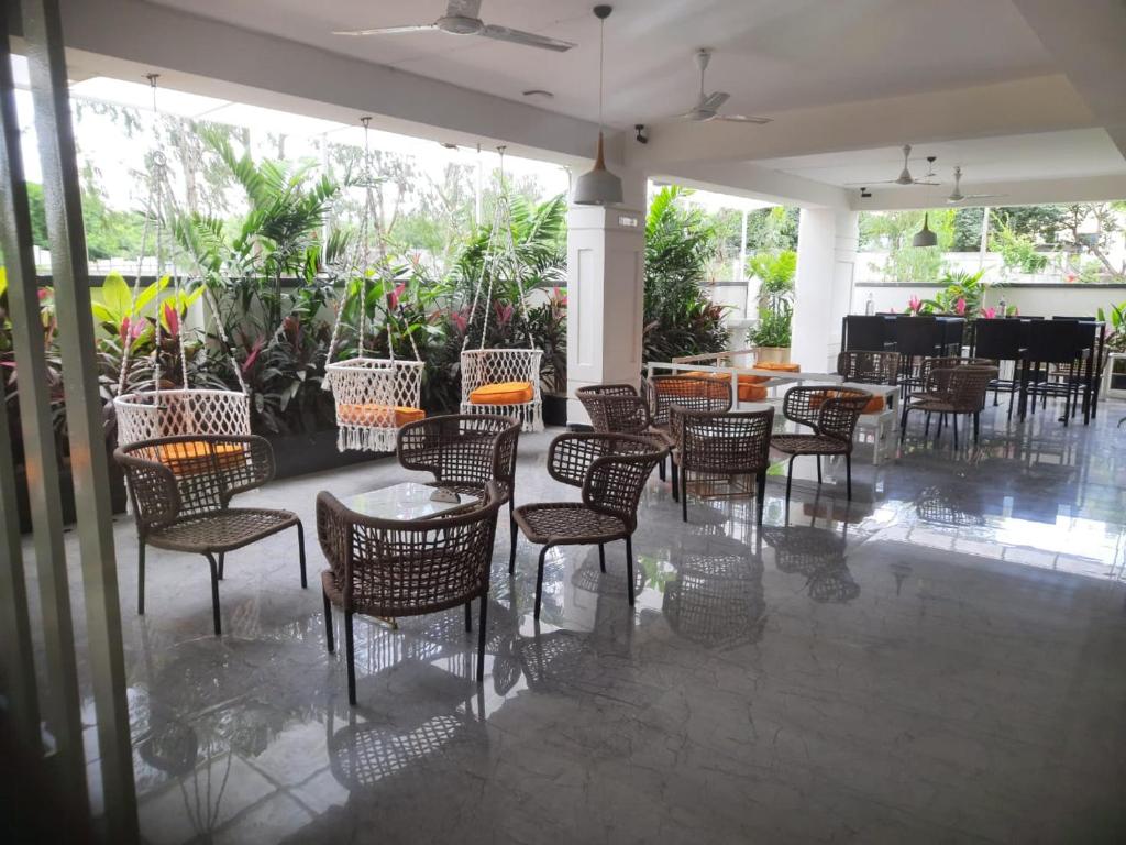 um restaurante com cadeiras e mesas e mesa de cabeceira em The Embassy Suites em Hyderabad