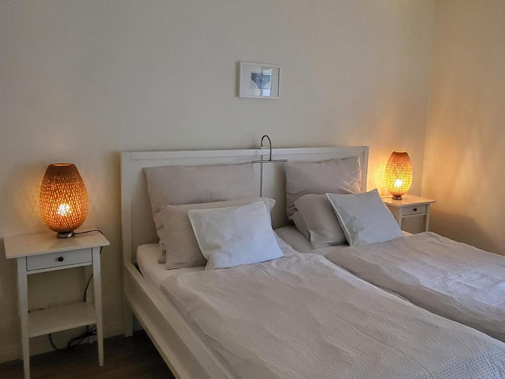1 dormitorio con 1 cama blanca y 2 lámparas en Ferienwohnung Worpswede-in-Sicht, en Lilienthal
