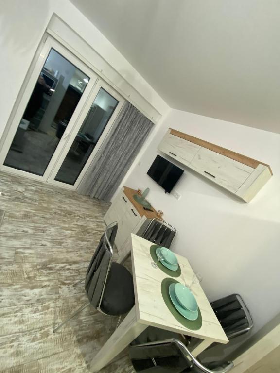 Habitación con mesa, sillas y ventana en Apartman Dunja, en Divčibare