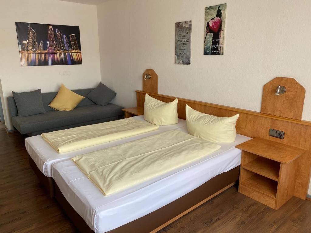 a bedroom with two beds and a couch at Hotel Sonne - Haus 1 in Idstein