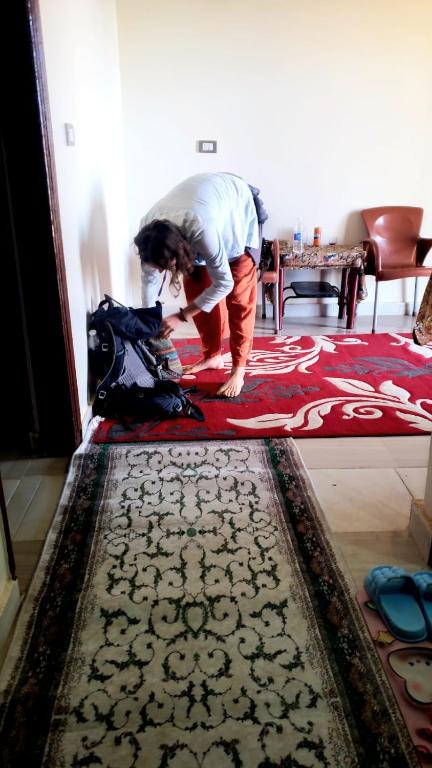 a woman is standing on a rug on a floor at Mooody nobin haws in Abu Simbel